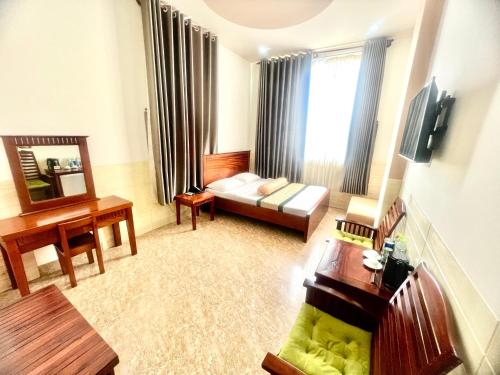 uma sala de estar com um sofá e uma mesa em XUÂN HUỲNH 3 Hotel em Soc Trang