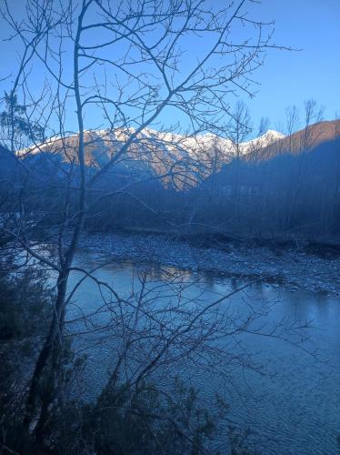 a river with snow capped mountains in the background at Agriturismo Summus Lacus in Riva