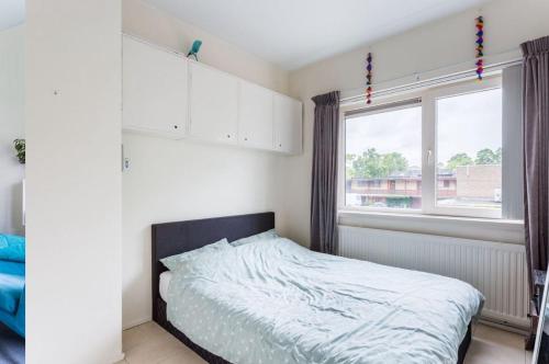 een slaapkamer met een bed en een groot raam bij Newa 1 in Amstelveen