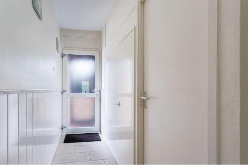 um corredor branco com uma porta e uma janela em Newa 1 em Amstelveen