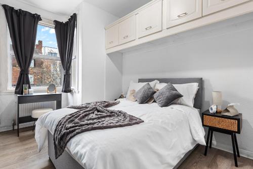 Un dormitorio blanco con una cama grande y una ventana en 1BDR Flat FREE Parking FREE Netflix & Wi-Fi, en Goodmayes