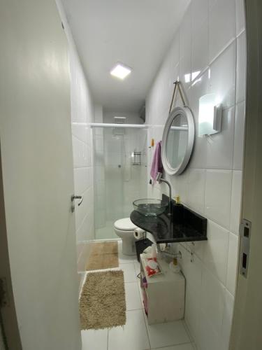 a bathroom with a toilet and a sink and a mirror at Apto 3 dorm, aconchegante , próximo a beira mar . in Florianópolis