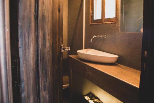 a bathroom with a white sink and a mirror at Estancia San Alberto Lodge in Uspallata