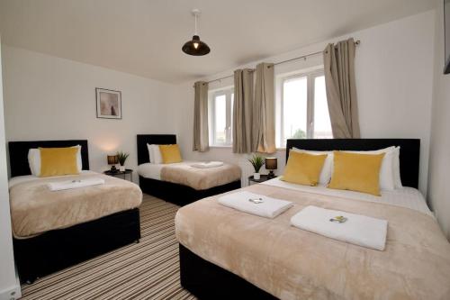 - une chambre avec 2 lits et des oreillers jaunes dans l'établissement Highley's Nest - Fully Furnished Gem, Free Private Parking, Sky TV & Netflix, à Coventry