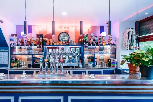 um bar com um balcão azul e uma prateleira de álcool em Hotel De La Poste em Paris