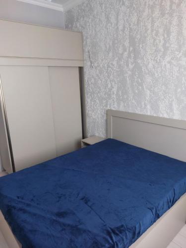 1 dormitorio con 1 cama con manta azul en House on Dolidze, en Rustavi