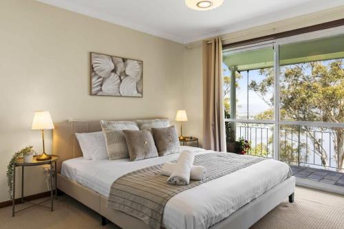 1 dormitorio con cama grande y ventana grande en Breathtaking Water Vista - Pool Table, en Empire Bay