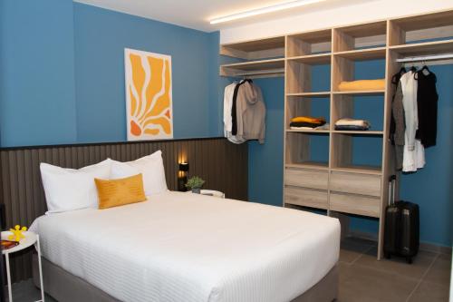 een slaapkamer met een bed en een blauwe muur bij NIU Reforma in Mexico-Stad