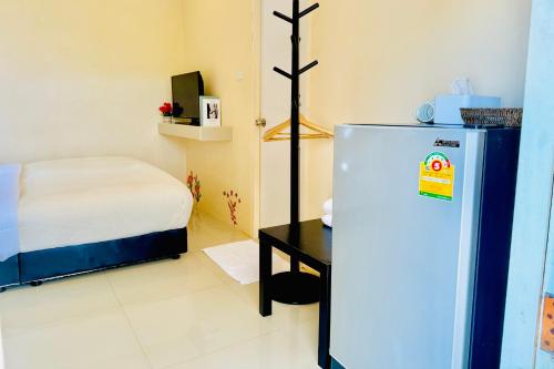 a small room with a refrigerator and a bed at BLUE OCEAN kohlarn resort in Ko Larn