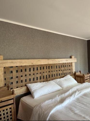 a bedroom with a large bed with a wooden headboard at Estancia San Alberto Lodge in Uspallata
