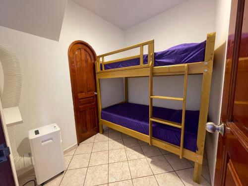Pokój z 2 łóżkami piętrowymi i fioletową pościelą w obiekcie Casita en el centro de la ciudad w mieście Iquitos