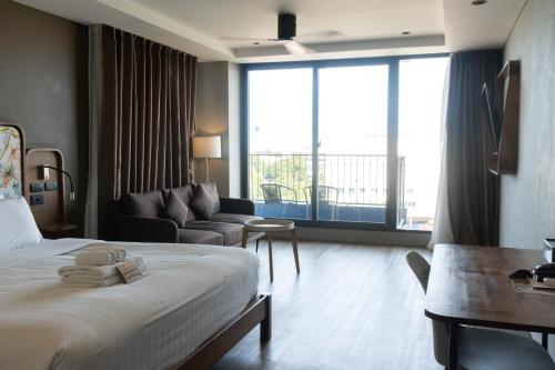 a hotel room with a bed and a couch at Seamira House Huahin in Hua Hin