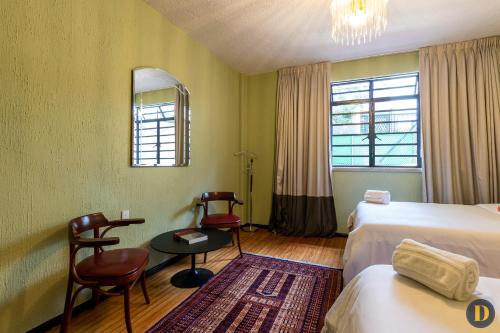 um quarto de hotel com duas camas e uma mesa e cadeiras em 101 Lindo y práctico 1 BR Polanco em Cidade do México