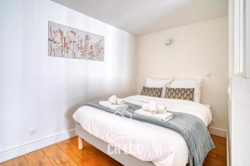 - une chambre avec un lit et 2 serviettes dans l'établissement Le Rodier - 10mn de Paris - Netflix et IPTV, à Maisons-Alfort