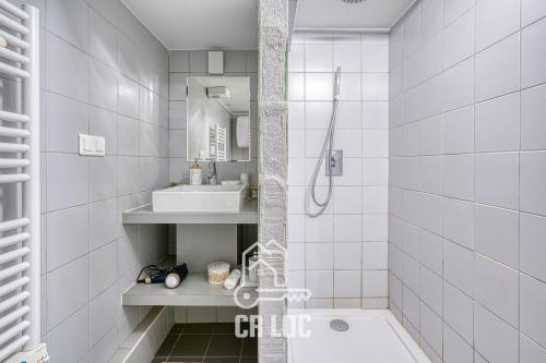 La salle de bains blanche est pourvue d'une baignoire et d'un lavabo. dans l'établissement Le Rodier - 10mn de Paris - Netflix et IPTV, à Maisons-Alfort