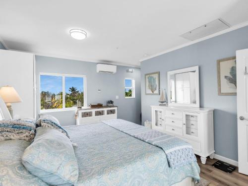 a bedroom with a bed and a dresser and windows at Atlantic Breeze NEW 1Bed 2Bath Condo in Marathon