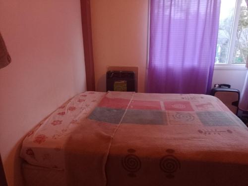 1 dormitorio con 1 cama con edredón en Caluvi en Ushuaia
