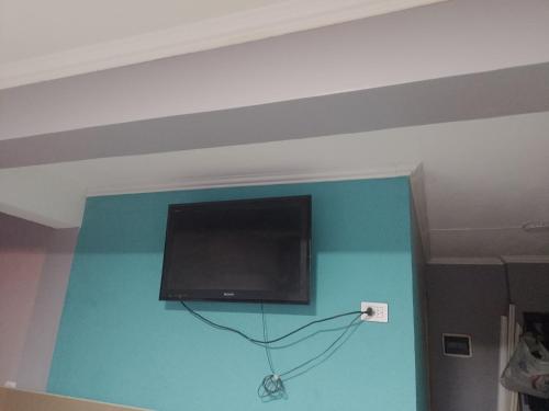 TV de pantalla plana colgada en una pared azul en Caluvi en Ushuaia