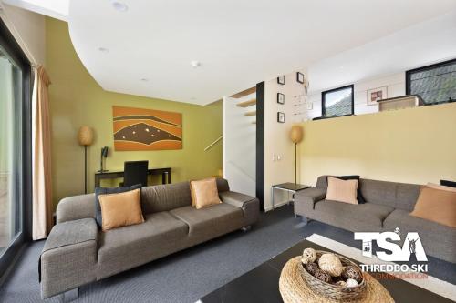 a living room with two couches and a table at Oberdere 2 in Thredbo
