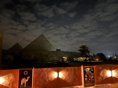 a view of the pyramids of giza at night at Energy Of Pyramid Hotel in Cairo