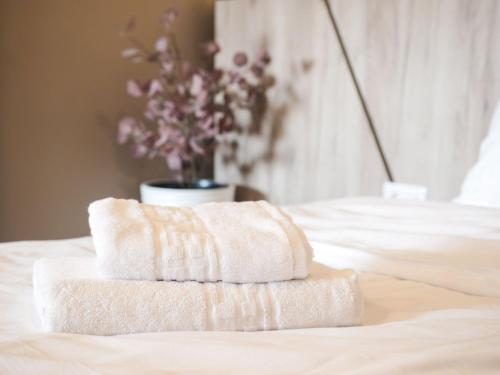 a stack of towels sitting on top of a bed at GAVAS Jacuzzi Relax Zen in Cluj-Napoca