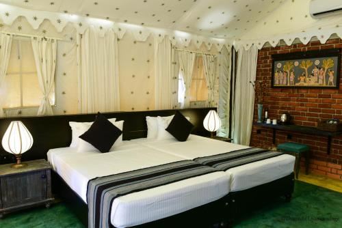 a bedroom with a large white bed with two lamps at Rangiri Dambulla Resort in Dambulla