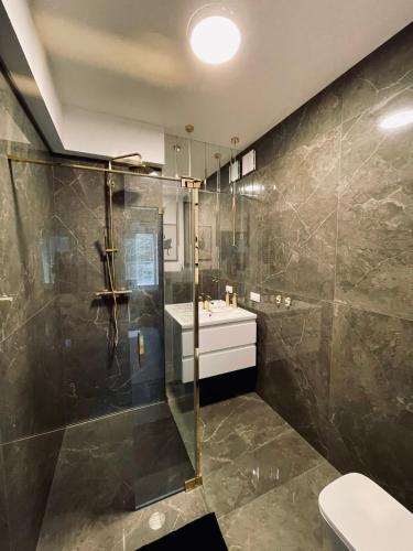 a bathroom with a shower and a sink at Apartament Bohaterów Westerplatte in Giżycko