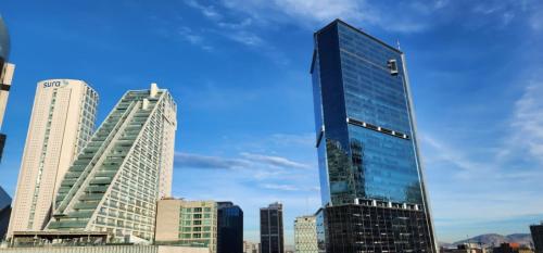 a tall glass building in a city at NIU Reforma in Mexico City