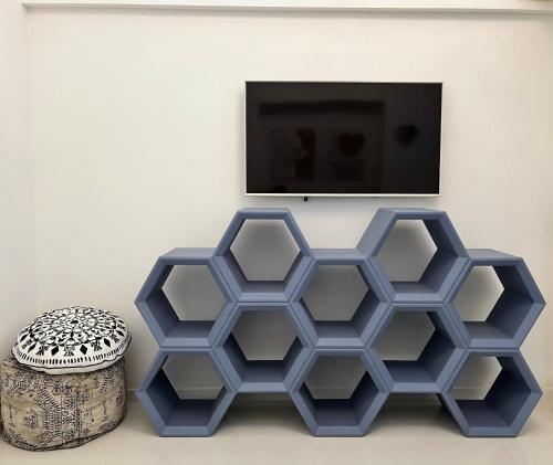 a living room with two blue hexagonal tables and a tv at Residenza Santi ai Monti in Rome