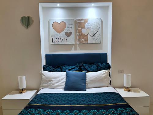 a bedroom with a bed with a blue headboard and two lamps at Residenza Santi ai Monti in Rome