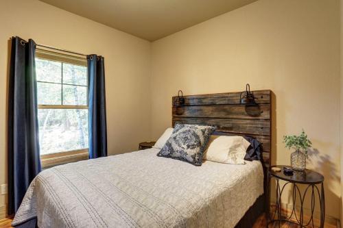 - une chambre avec un lit doté d'une tête de lit en bois et d'une fenêtre dans l'établissement Whiskey Barrel Cabin, à Lead