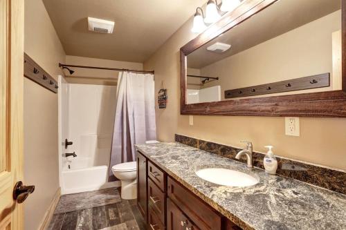 La salle de bains est pourvue d'un lavabo, de toilettes et d'un miroir. dans l'établissement Whiskey Barrel Cabin, à Lead