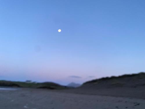 a person walking on the beach at sunset at Country Cabin in Mullagh