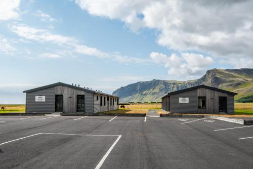 two buildings in a parking lot with mountains in the background at Boutique Hotel Anna by EJ Hotels in Holt