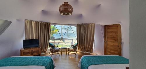 a bedroom with two beds and a window at Malipaya Villas in General Luna