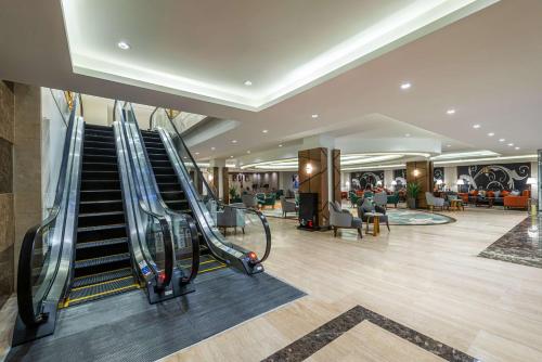 an empty lobby with an escalator in a mall at Best Western Plus Tabuk City Center in Tabuk