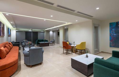 a living room with couches and chairs and tables at Best Western Plus Tabuk City Center in Tabuk