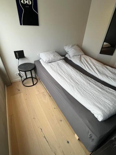a bed in a room with a side table at Ekslusiv lejlighed in Herning