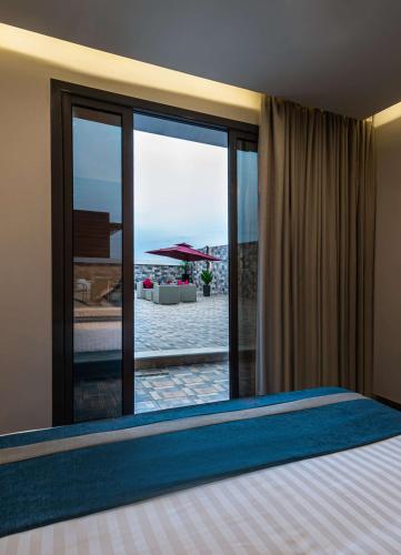 a bedroom with a bed and a view of the beach at Best Western Plus Tabuk City Center in Tabuk