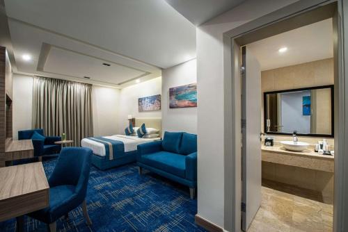 a hotel room with a bed and a bathroom at Best Western Plus Tabuk City Center in Tabuk