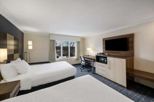 a hotel room with a bed and a desk with a television at Best Western - Freeport Inn in Freeport