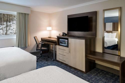 a hotel room with a desk with a television and a bed at Best Western - Freeport Inn in Freeport