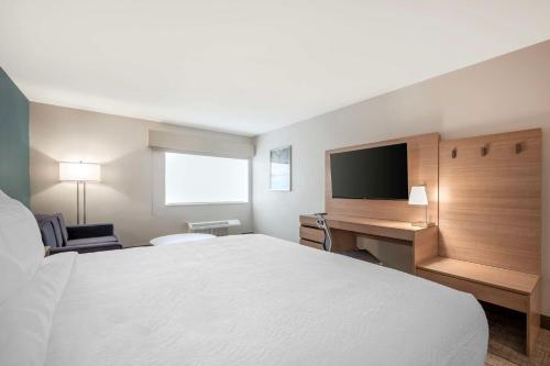 a hotel room with a bed and a desk and a television at Best Western River Cities in Ashland