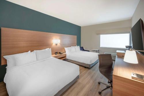 a hotel room with two beds and a desk and a chair at Best Western River Cities in Ashland