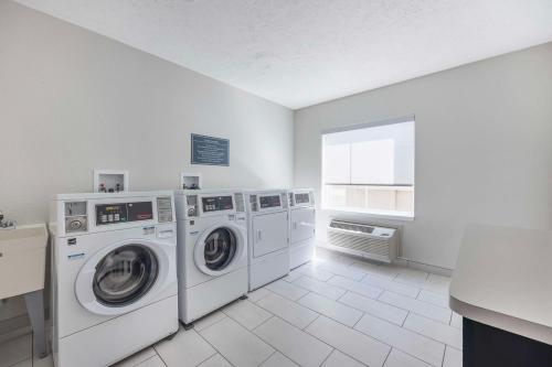 a laundry room with two washing machines and a window at Best Western Plus Owensboro in Owensboro