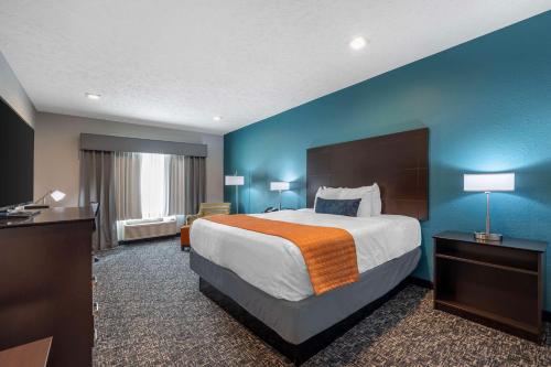 歐文斯伯勒的住宿－Best Western Plus Owensboro，酒店客房设有一张大床和蓝色的墙壁。