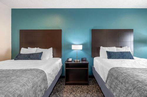 two beds in a hotel room with blue walls at Best Western Plus Owensboro in Owensboro