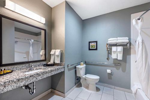 a bathroom with a toilet and a sink and a mirror at Best Western Plus Owensboro in Owensboro