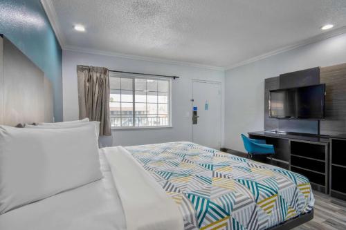 a bedroom with a bed and a flat screen tv at Studio 6 Suites San Bernardino, CA in San Bernardino