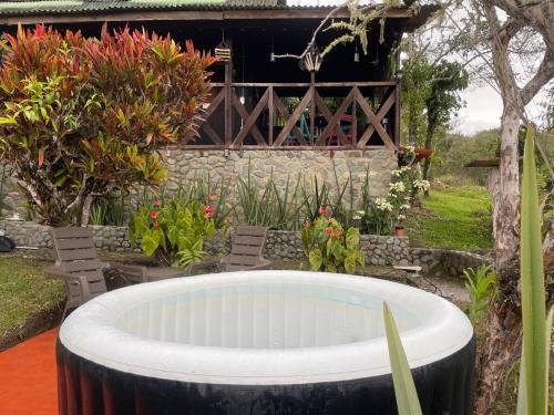 a large pool in a garden with chairs and flowers at Casa Campestre estilo Chalet Los Pirineos - Cerca a Cali in Cali